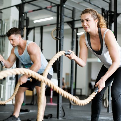 Fitness people working out with battle ropes