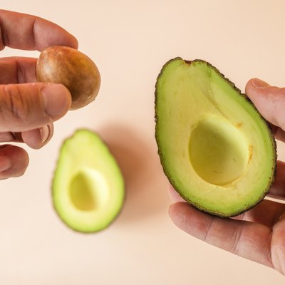 hands preparing avocado for eating.