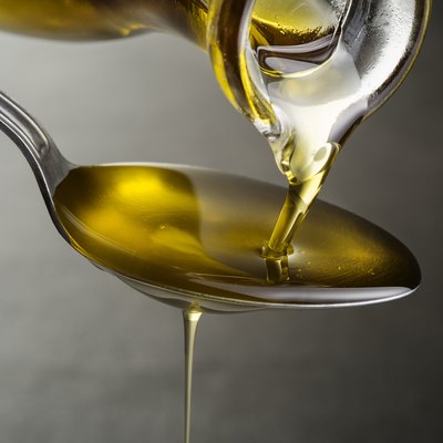 Oil pouring and dripping to the spoon