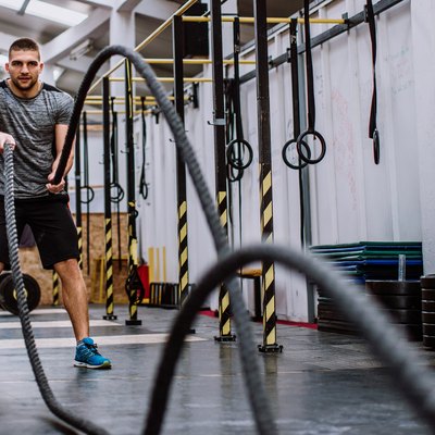 Man Doing Battle Rope Workout in the Gym