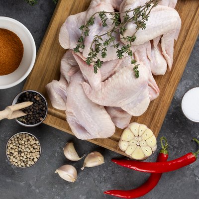 Raw chicken on cutting board with herb and spices