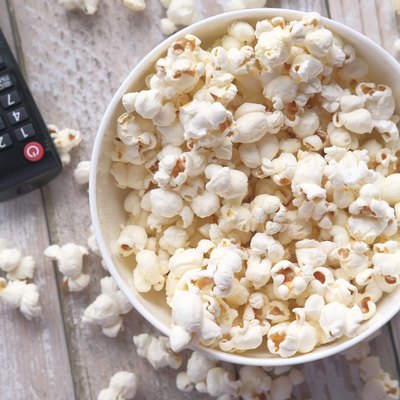 remote control and popcorn in a bowl