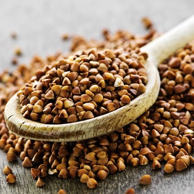 Wooden spoon filled with buckwheat grain
