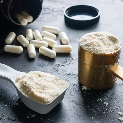 two measuring spoons of protein and creatine close-up on a black background