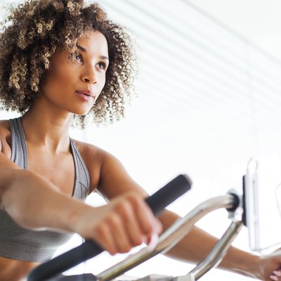 Woman Doing Cardio Exercises on a Stationary Bike at the Gym