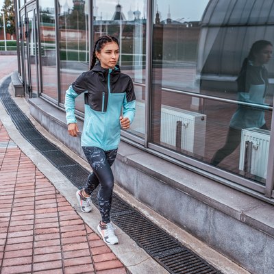 Woman athlete girl runs in the city in autumn in spring, fitness workout, motivation is power. Active lifestyle. Sportswear, free space, achievement, success, endurance competition.