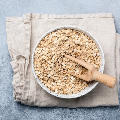 Oats or oat flakes in bowl on linen textile