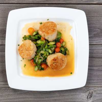 Freshly seared scallops and vegetables ready to serve