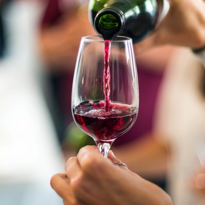 Cropped Hands Pouring Red Wine In Wineglass