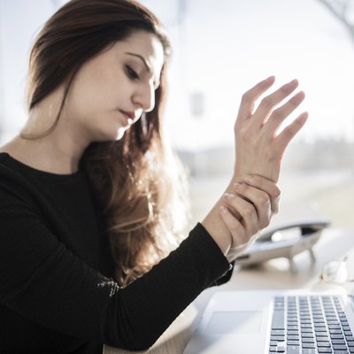 Woman working with computer and having wrist pain