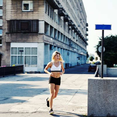 Young woman running on city street