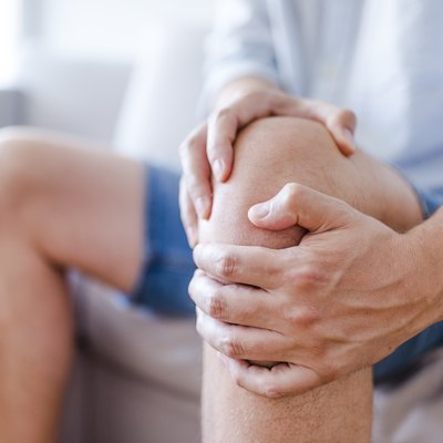 A mature man massaging his painful knee