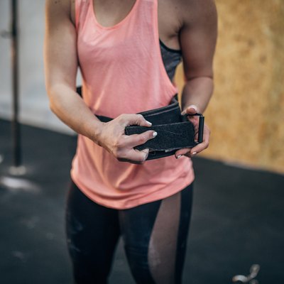 Woman putting on belt for dead lift training