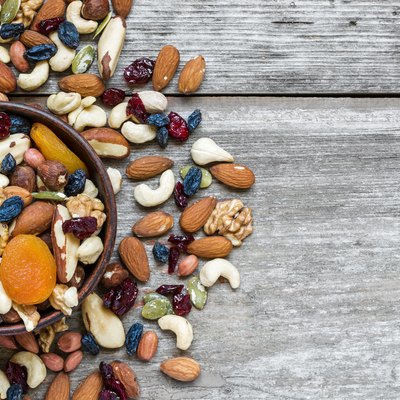 nuts and dried fruits in a bowl over rustic wooden table