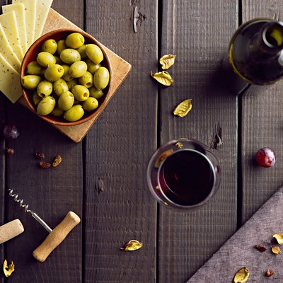 Red vine served with green olives and cheese.