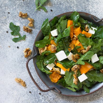 Concept diet menu, Vegan food. Salad with baked pumpkin, feta, cheese and vinaigrette dressing on stone background. Top view flat lay. Free space for your text.