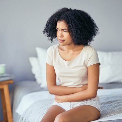 Woman holding stomach because of excessive bowel movements.