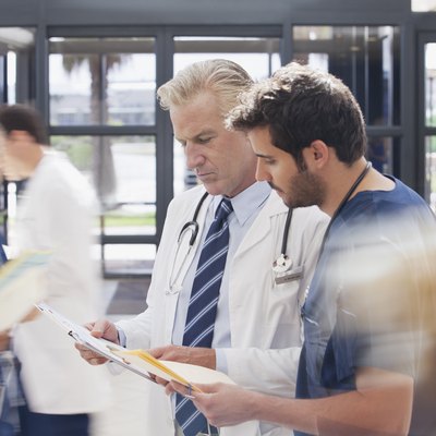 Doctor and nurse reviewing medical record in hospital