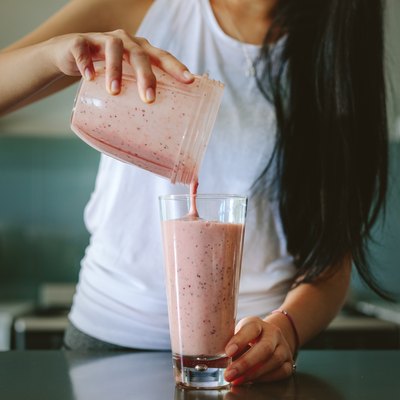 Woman preparing fresh fruit smoothie