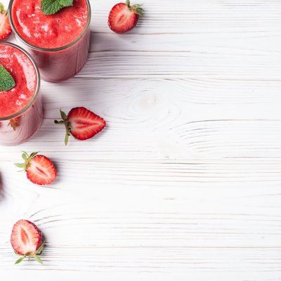 Strawberry smoothie in glass on white background with copy space. Summer drink cocktail. Healthy eating dieting and breakfast concept