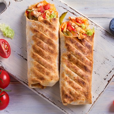 Chicken wraps with tomatoes, pickles, cabbage and onion. Tortilla, burritos, sandwiches, twisted rolls