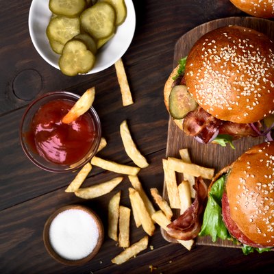 Burger and french fries on wooden table.