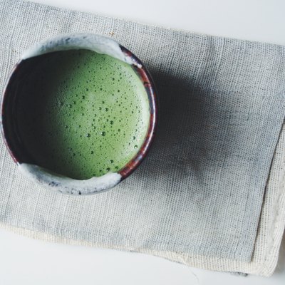 Bowl of Matcha green tea prepared in traditional ceremonial manner, high angle view.
