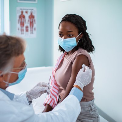 Young woman getting flu shot at doctor's office