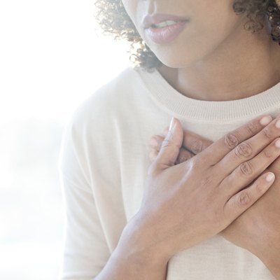 Woman touching her chest because she has shortness of breath