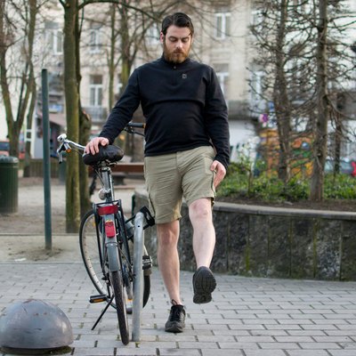 Man performing leg swing before a bike ride