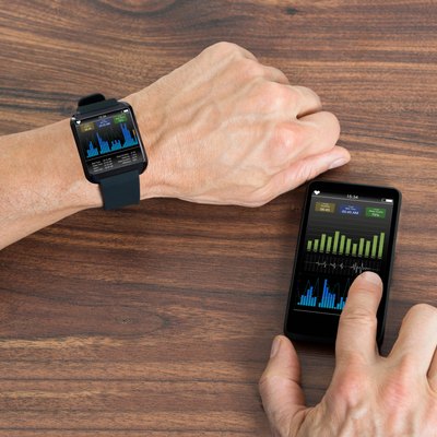Man With Smartwatch And Cellphone Showing Heartbeat Rate