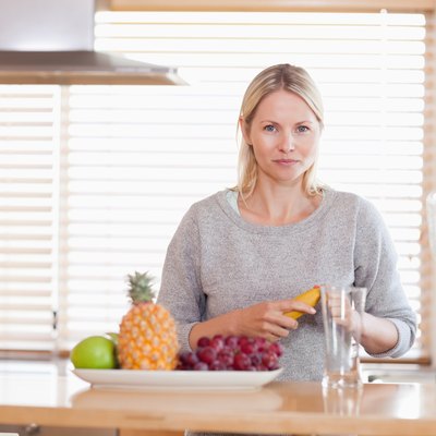Woman preparing fruits for the blender