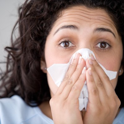 Woman with flu blowing nose