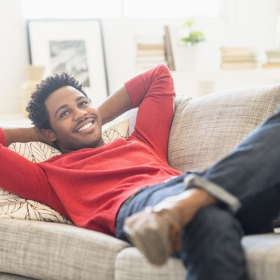 Man lying on sofa and smiling