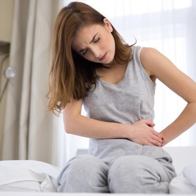 A young woman, her stomach, pain