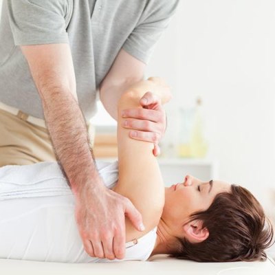 A therapist, a patient's shoulder