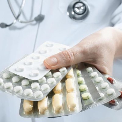 A doctor, antibiotic packets, his hand