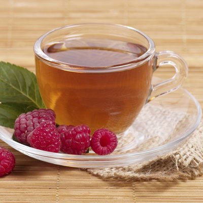 Fruit tea in cup with raspberry