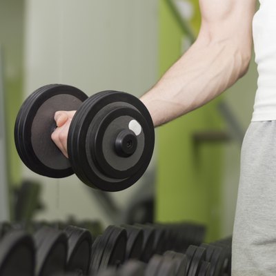 Unrecognizable person taking dumbbells in a gym