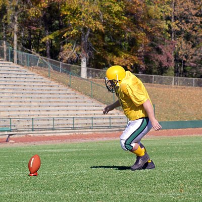 Football kicker practicing on field