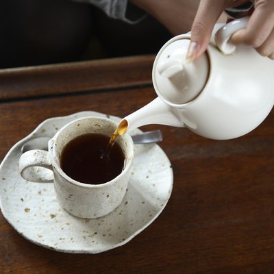 Close-up of a Hand Pouring Tea