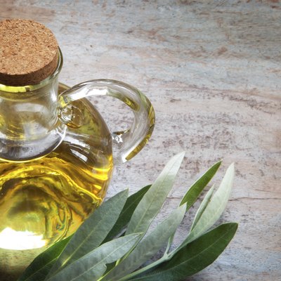 Olive Oil and Leaves on Rustic Timber