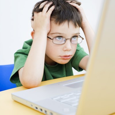 Frustrated boy using laptop computer