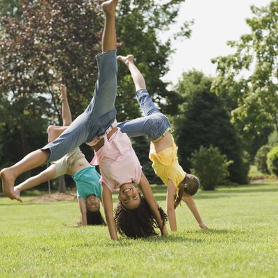 Girls doing cartwheel in field