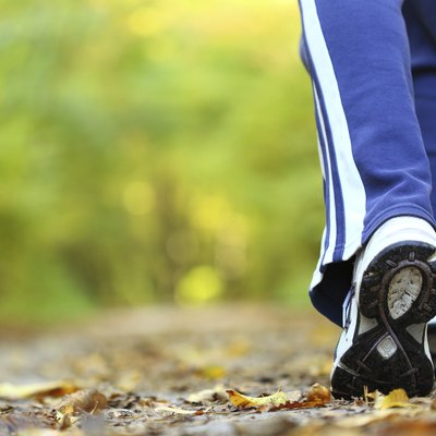 Woman walking cross country trail in autumn forest