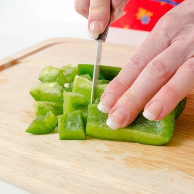 Hands of woman cutting green pepper