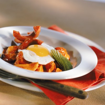 Poached egg on plate with fork, close-up