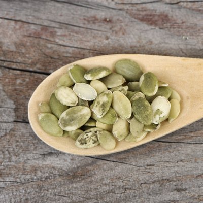 Pumpkin seeds in a wooden spoon.