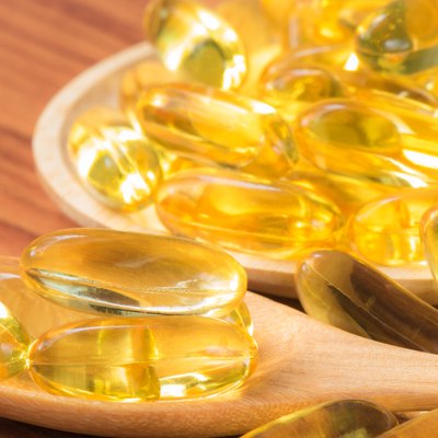 Close-up Fish oil capsules on wooden spoon