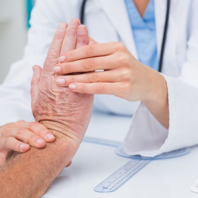 Physiotherapist examining male patients wrist